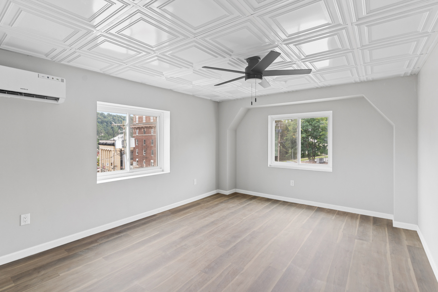 Room at Ivy Gardens showing the decorative pressed-metal ceiling and two large windows